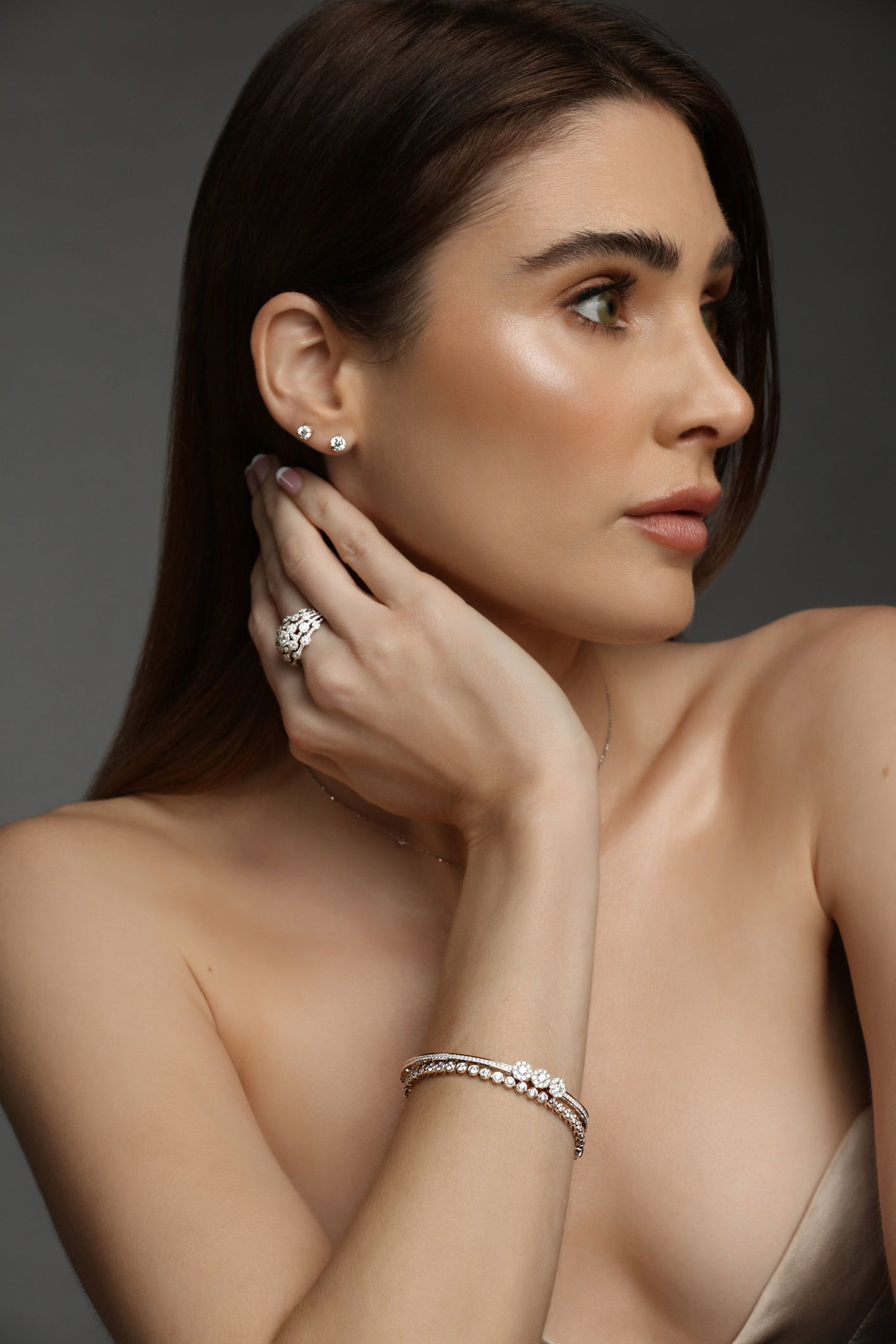 Studio photograph of model wearing a fine jewellery set with necklace, ring, and bracelet