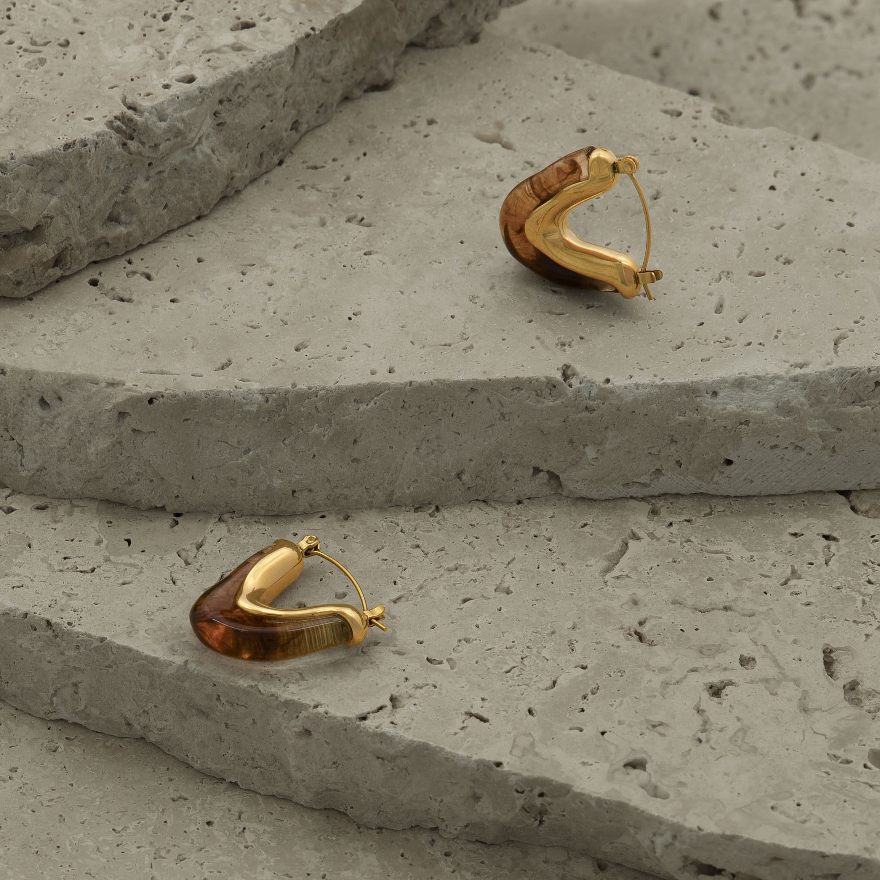 Earrings styled on natural stones and photographed in a Brisbane studio, highlighting design, texture, and visual appeal for lifestyle and marketing images